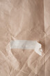 © Floral Deco - Close-up of Torn Brown Paper With Tape. Torn Brown Kraft Paper with Ripped Strip Revealing White Layer