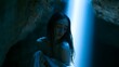 © decorator - Serene woman bathed in blue cave light evokes tranquil beauty and a peaceful emotional portrait