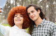 © Westend61 - Smiling beautiful woman with young man taking selfie on smart phone at forest