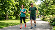 © Len_mik - Middle aged couple jogging together in a sunny park. Happy man and woman enjoying outdoor fitness and active lifestyle