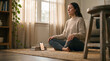 © Diego Thetower - Woman Meditating at Home Using Guided Breathing App on Phone