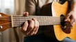 © kurnia - Hands playing acoustic guitar. Musician practicing chords on a wooden string instrument.