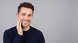 © Creative Stocker - A smiling young man with short brown hair wearing a dark blue sweater, touching his cheek ad social media download thambnail poster web template event festival 2026 2027 2028