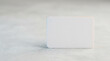 © Ahmad - Blank White Rectangular Card with Rounded Corners on a Textured Light Gray Surface with Subtle Color Reflections