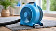 © Nataliya - Blue industrial air mover fan drying a wet carpet for water damage restoration, home restoration service  , with copy space