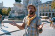 © Vitalii Shkurko - Professional Guide Answers Tourist Questions at a Famous Monument in a Busy Square