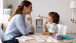© Alexey - Speech therapist working with young boy on pronunciation. Professional teacher helping child with special needs during sensory lesson. Educational session for speech development and learning.