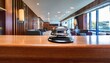 © Jessica - a shiny silver hotel reception bell rests on a polished wooden front desk within a luxurious lobby area creating a professional atmosphere
