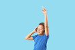 © Pixel-Shot - Little African-American boy with headphones listening to music on blue background