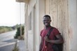 © Cavan Images - Young Black man with a backpack smiling outdoors