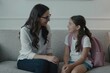 © jollier_ - Mother and daughter share a moment before school on a couch in a living room