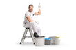 © Ljupco Smokovski - House painter sitting on a stepladder with paint buckets and pointing up
