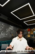 © LIGHTFIELD STUDIOS - Working diligently in a modern recording studio, a young man brings music to life