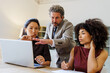 © BONNINSTUDIO/Stocksy - Professionals collaborating on laptop during business meeting