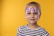 © New Africa - Little girl with beautiful face painting on orange background, space for text