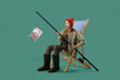 © Pixel-Shot - Surprised young woman with fishing rod and magazine on green background