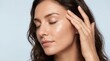 © Giga - Relaxed woman with closed eyes touching face against soft blue background with serene woman touching her tranquility relaxation horizontal