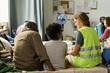 © pressmaster - Black father and child sitting with Caucasian aid worker, discussing support in temporary shelter. Ideal for humanitarian outreach, refugee assistance, social care campaigns