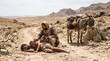 © Devaji - The Good Samaritan helping a wounded, beaten man on a dusty desert road. Biblical parable of mercy and compassion