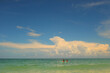© Cavan Images - Two people paddleboarding under a big blue sky