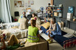 © pressmaster - Wide shot of diverse adults receiving support in temporary shelter, volunteers coordinating aid and check-in. Ideal for humanitarian relief, crisis response, social care campaigns
