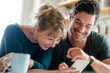 © Westend61 - Happy couple looking at smartphone together