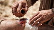© Akash Tholiya - The Good Samaritan helping a wounded, beaten man on a dusty desert road. Biblical parable of mercy and compassion