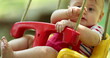© Marco - Adorable baby infant on playground swing happy