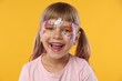 © New Africa - Little girl with beautiful face painting on orange background