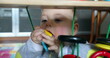 © Marco - Cute baby boy playing with arch toy at home putting in mouth