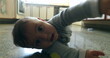 © Marco - Casual authentic scene of baby infant on kitchen floor wanting to touch camera lens