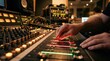 © Rasyid - A dedicated professional sound engineer carefully adjusts the glowing faders on a large mixing console to create a perfect audio balance inside a high performance musical recording facility
