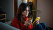 © Emanuel - Young Latina woman frustrated at home after missing online shopping deals on her smartphone, representing digital shopping disappointment, missed opportunities, consumer emotions