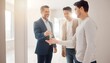 © EBG Stock Studio - Hombre de negocios estrechando la mano de un joven durante una reunión profesional con otro participante al fondo en un espacio luminoso