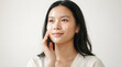 © PTC - Radiant Young Asian Woman With Natural Glowing Skin Touching Her Face for Beauty and Skincare Routine Concept