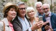 © Bussakon - A group of older adults outdoors looking at a smartphone screen together during daylight with natural stone background