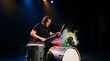 © Julian - Male drummer playing musical percussion with exploding colored powder