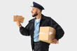© Pixel-Shot - Handsome postman with letters and parcel on white background