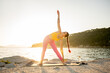 © ADDICTIVE STOCK - Woman practicing yoga by the sea at sunrise for balance