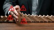© Maryna - Man in suit stops falling dominoes cascade, prevents business crisis, warns of danger with alert signs. Strategic risk control ensures operational stability and process protection from disruptions.