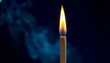 © Arief - Burning slim candle or match flame with smoke on dark blue background