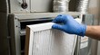 © SimpleDesignStudio - Technician wearing blue gloves replacing an air filter in a residential HVAC heating and cooling system