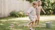 © Nina - Two joyful toddlers playing outdoors in a sunny backyard with a wooden toy and metal bucket