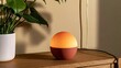 © Senang - A glowing orb lamp sits on a wooden surface next to a plant