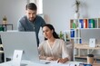 © Prostock-studio - Focused Female Professional Of Latin Descent And Male Colleague Working Together On Computer In Modern Office Environment, Analyzing Data And Discussing Ideas. Business Concept.