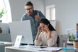 © Prostock-studio - Worried Hispanic Female Employee Holding Head While Male Colleague Gestures At Her In Stressful Office Setting, Feeling Overwhelmed And Stressed At Work. Business Concept.