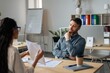 © Prostock-studio - Focused Caucasian Man Engaging In Discussion With Female Colleague, Analyzing Documents At Office Setting. Professional Conversation Highlighting Business Concept And Collaboration.