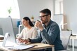 © Prostock-studio - Focused Caucasian Man Working On Computer While Drinking Coffee, Accompanied By Female Colleague In Modern Office Setting. Engaged In Professional Task, Exhibiting Active Work Lifestyle, Business