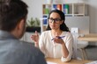 © Prostock-studio - Focused Woman Of Latin American Descent Engaging In Discussion With Male Colleague In Modern Office, Demonstrating Professional Communication And Collaboration. Business Concept.