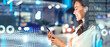 © Prostock-studio - Smiling Young Asian Woman Engaged With Smartphone While Standing At Street With Bright City Lights At Night, Demonstrating Modern Technology Usage. Emphasizing Connection And Innovation.